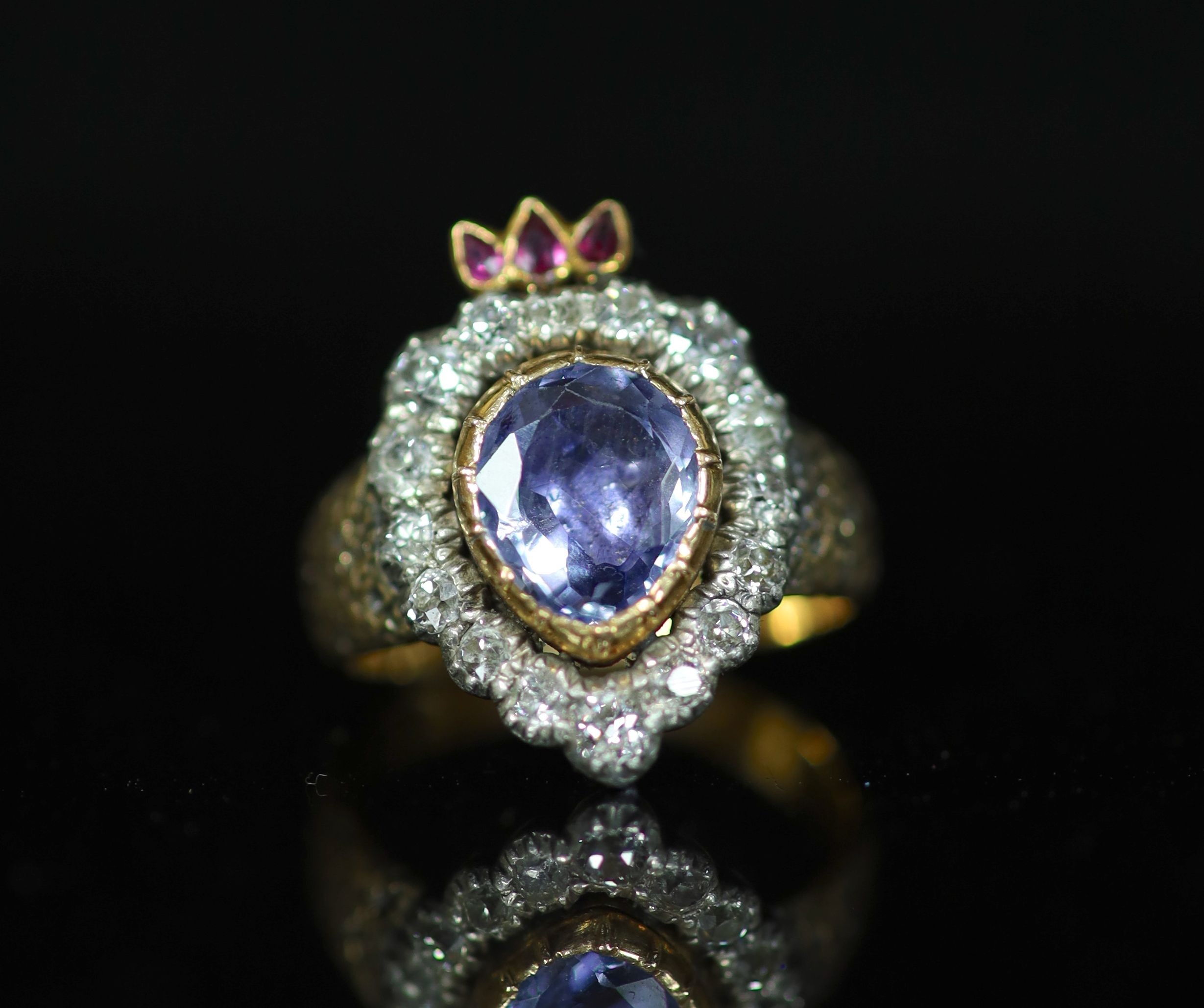 A 19th century gold, pear shaped sapphire, ruby and old cut diamond set flaming heart ring